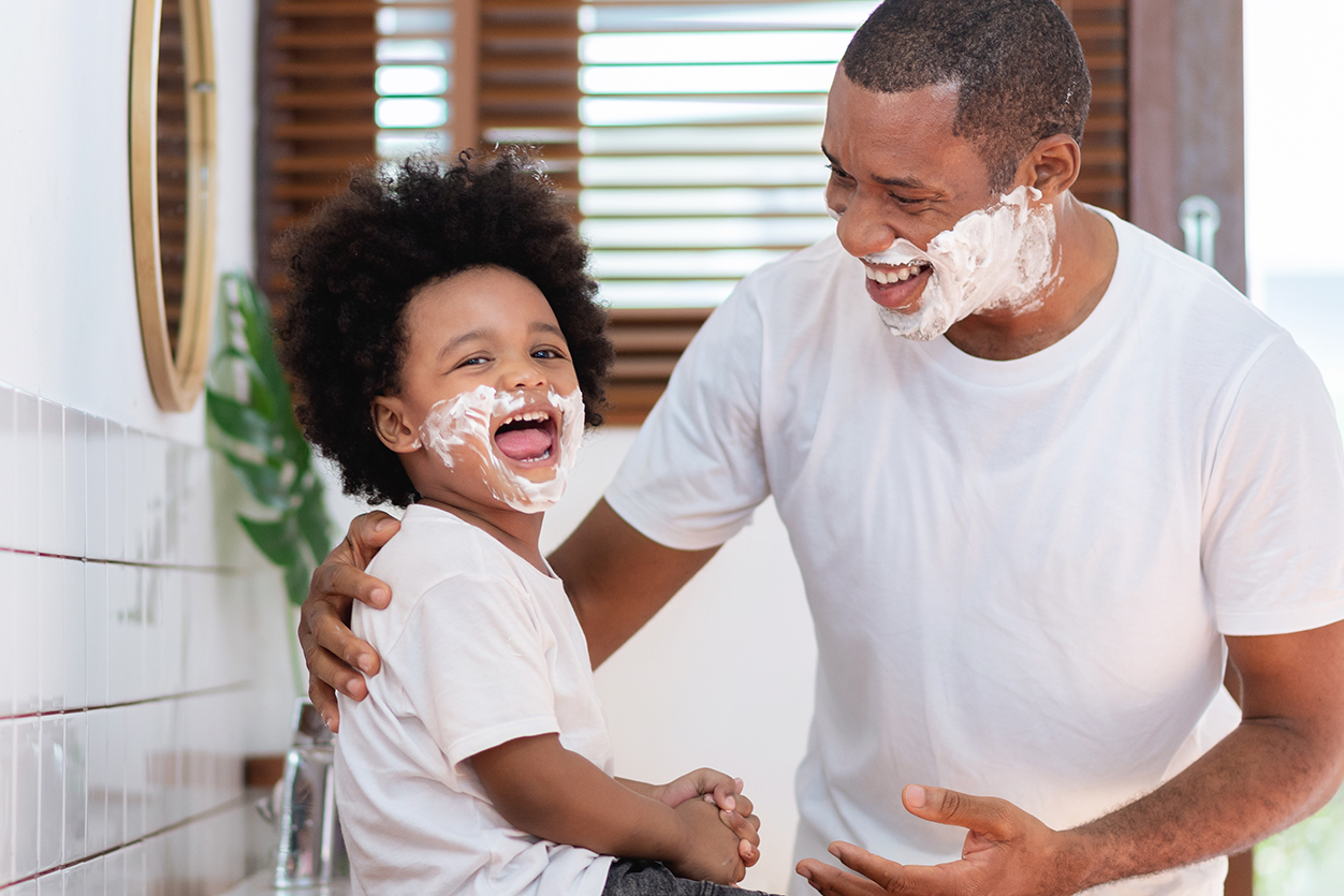 Father teaching child to shave.